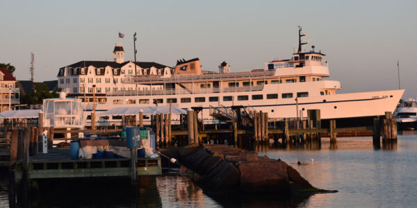 Docked ferry boat near a large white hotel during golden hour at the Block Island harbor